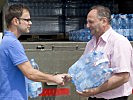 Prokutist Rechberger übergibt das Wasser an Bürgermeister Müllner.