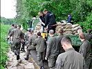 Unermüdlich sichern die Soldaten mit Sandsäcken den Damm in Theiß.