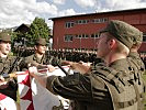 Stellvertretend für ihre Kameraden gelobten vier Soldaten mit der Hand an der Fahne.