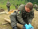 Ein Stück Holz wird mit plastischem Sprengstoff zur Sprengung vorbereitet.