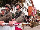 Mit der Hand an der Fahne sprechen die Rekruten das Treuegelöbnis.