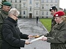 Zugsführer Saskia Biel überreicht das Abzeichen an die Enkelin des Namensgebers, Gertrud Magerl.