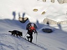 Ein Hundeführer und sein Lawinenhund auf dem Weg zum Unglücksort.