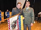 Generaldirektor Harold von der HYPO/NÖ befestigt das gestiftete Fahnenband.