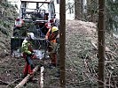 Soldaten befestigen Baumstämme zum Wegziehen mit der Seilwinde.