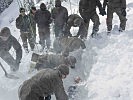 Nach schweißtreibender Schaufelarbeit wird eine Übungspuppe geborgen.