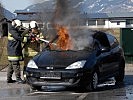 Die Grundwehrdiener löschen ein brennendes Auto.