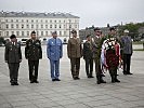 Die Delegationsleiter legen am Grab des unbekannten Soldaten einen Kranz nieder (im Hintergrund das Gebäude des Garnisonskommandos Warschau).