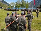 Mit der Hand an der Insignie sprechen vier Rekruten stellvertretend für ihre Kameraden das Gelöbnis.