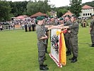 Vier Rekruten sprechen ihr Treuegelöbnis an der Insignie des Bataillons.