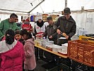 Gemeinsam mit freiwilligen Helfern unterstützen Soldaten bei der Verpflegsausgabe.