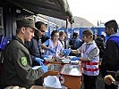 Die Studenten geben gemeinsam mit Soldaten die Verpflegung aus.