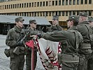 Mit der Hand an der Insignie sprechen vier Rekruten stellvertretend für ihre Kameraden das Treuegelöbnis.