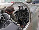 Ein Flugzeugwart überprüft das Cockpit.