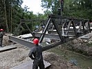 Mit dem neuen Autokran wird die Pionierbrücke über dem Wimsbach eingehoben.