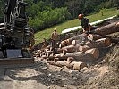 Die Soldaten schneiden Baumstämme einer "Krainerwand" zu.