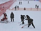 Die Maschinen schleudern die Schneemassen über die Absperrungen.