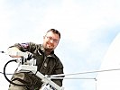 Offiziersstellvertreter Anton Söser richtet die Antenne auf den Satelliten aus.