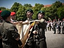 Vier Rekruten sprachen das Treuegelöbnis mit der Hand an der Insignie.