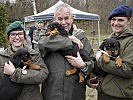 Bundespräsident Van der Bellen mit Mitarbeiterinnen und Welpen des Militärhundezentrums.