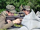 Wachtmeister Carmen W. zeigt ihrem Soldaten wie das Sturmgewehr im Liegen richtig in Anschlag gebracht wird.