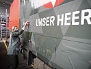 Ministerin Klaudia Tanner bei der Beklebung der neuen ÖBB-Lok im Bundesheer-Design.