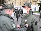 Der Zugskommandant heftet einem Soldaten die Einsatzmedaille an.