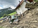 Salzburger Pioniere entfernen die Schlammmassen nach einer Vermurung bei einem Wohnhaus.
