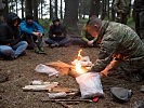 Ein Instruktor des Jagdkommandos zeigt, wie man mit einfachen Hilfsmitteln Feuer macht.