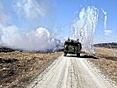 Ein Radpanzer verschießt Nebelgranaten, um sich zu schützen.