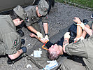 Ein Feuerwehrmann erleidet einen Kreislaufkollaps, das Sanitätspersonal des Bundesheeres leistet Erste Hilfe.