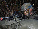 Ein Soldat beim Sichern in seiner Stellung, jederzeit bereit den Feuerkampf aufzunehmen.