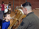 Dieser junge Mann versucht sich an der riesigen Tuba.