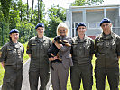 Klaudia Tanner mit einem der sieben Welpen und Militärhundeführerinnen.