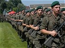 Die anzugelobenden Rekruten marschieren auf dem Sportplatz ein.