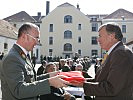 Bürgermeister Merlini (r.) erhält vom steirischen Militärkommandanten, Oberst Zöllner, die Flagge als Andenken an die Soldaten.