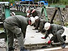 Die Fahrbahnplatten werden in Präzisionsarbeit händisch fixiert.