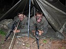 Zwei Soldaten in ihrem Nachtlager unter freiem Himmel.