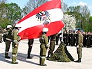 Soldaten und Feuerwehrleute hissen zusammen die Flagge.