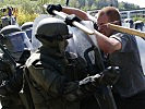 Die Soldaten müssen gewalttätige Demonstranten vom Gebäude fernhalten.