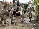 Einsatzkräfte beseitigen Schlamm und Geröll.