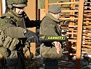 Der Milizsoldat setzt einen Metalldetektor bei der Personenkontrolle ein. (Bild öffnet sich in einem neuen Fenster)