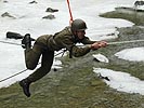 Ein Soldat überquert einen Fluss mit einem Seil