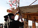 Oberstleutnant Lippert btingt das Bäumchen für die Gleichenfeier an. (Bild öffnet sich in einem neuen Fenster)
