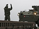 Ein Mannschaftstransporter wird auf einen Waggon gefahren. (Bild öffnet sich in einem neuen Fenster)