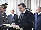 Bundeskanzler Kern beim Eintrag in das Krypta-Buch. (Bild öffnet sich in einem neuen Fenster)
