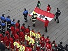 Vertreter der Einsatzorganisationen mit der Bundesdienstflagge. (Bild öffnet sich in einem neuen Fenster)