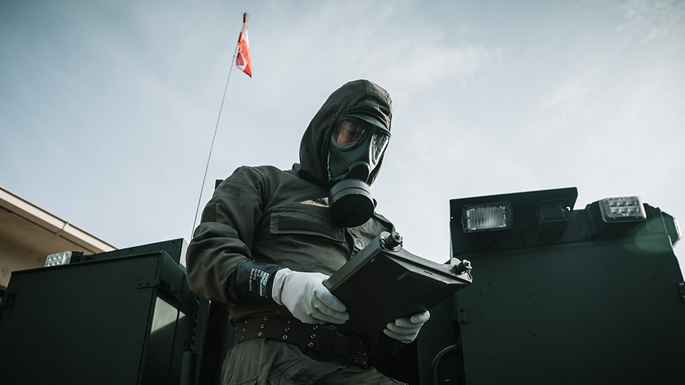 Galerie Bevölkerungsschutz: ABC Soldat mit Maske am Fahrzeug