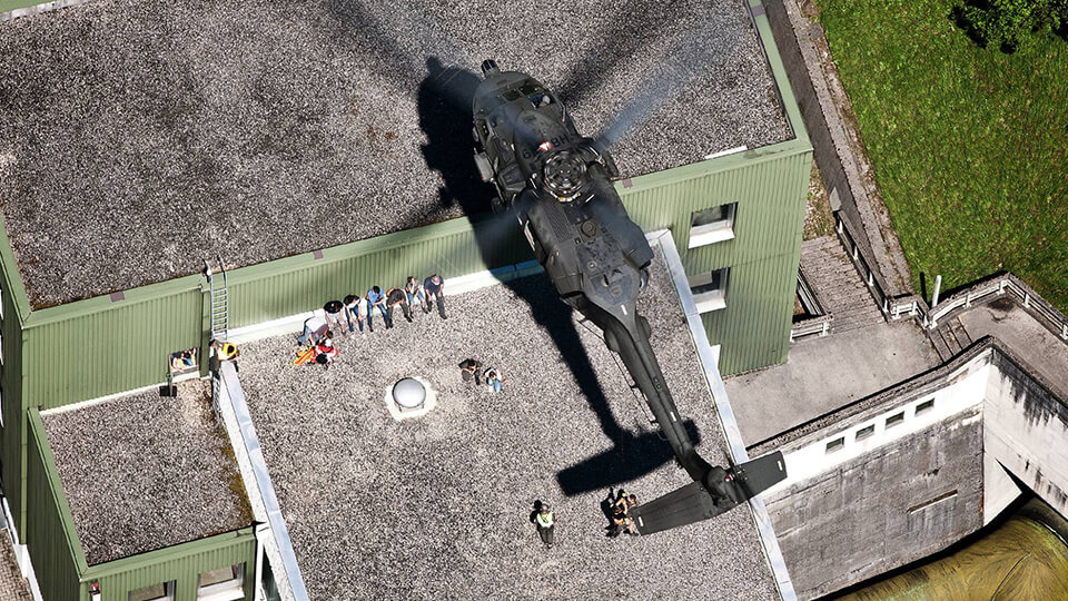 Hubschauber fliegt über Hallendach