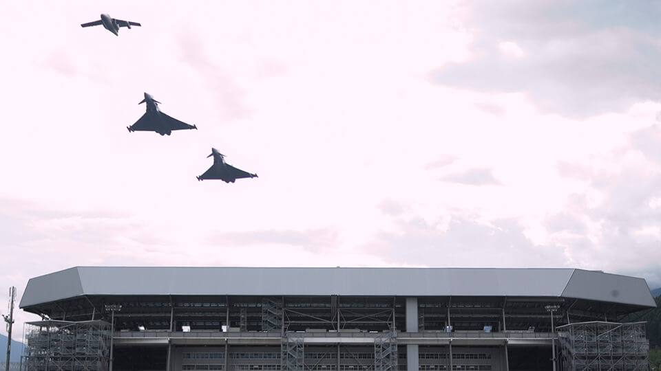 Kampfflugzeug Eurofighter EF 2000 des Österreichischen Bundesheereses fliegt über ein Stadium